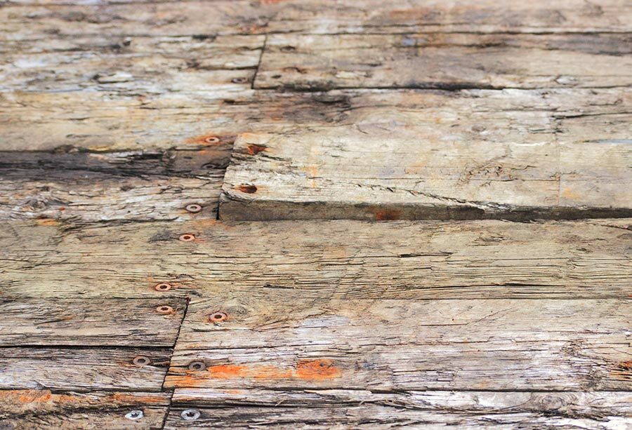 Schrauben und Befestigungen bei Terrassenboden prüfen