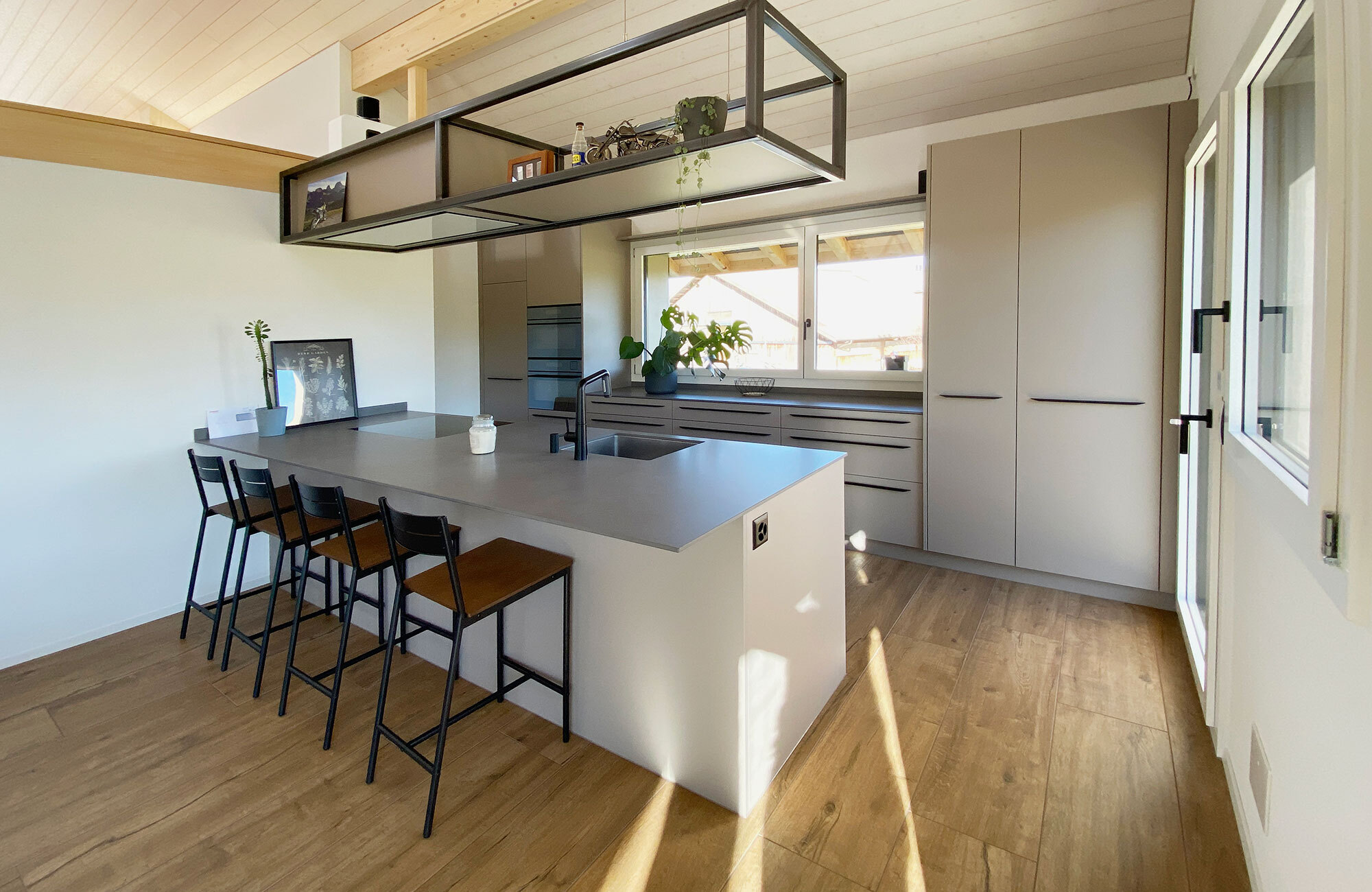 Moderne Küche mit in Metallrahmen eingebautem Dampfabzug